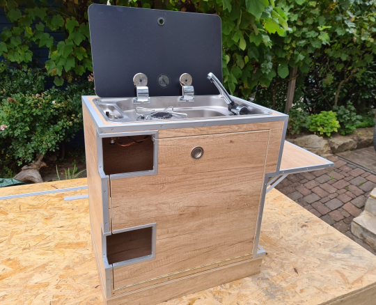 Praktisch organisierte Campingküche im Aluminiumkoffer – maßgefertigte Holzeinsätze für Gaszubehör, Kochgeschirr, Besteck und Gläser sorgen für Ordnung, schnellen Zugriff und klapperfreien Transport auf Reisen